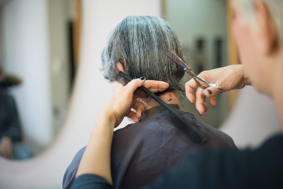 Barber styling a client's hair with product