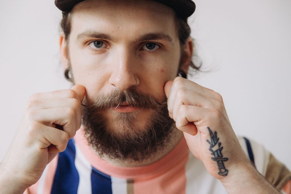 Man checking the shape of his beard with his fingertips