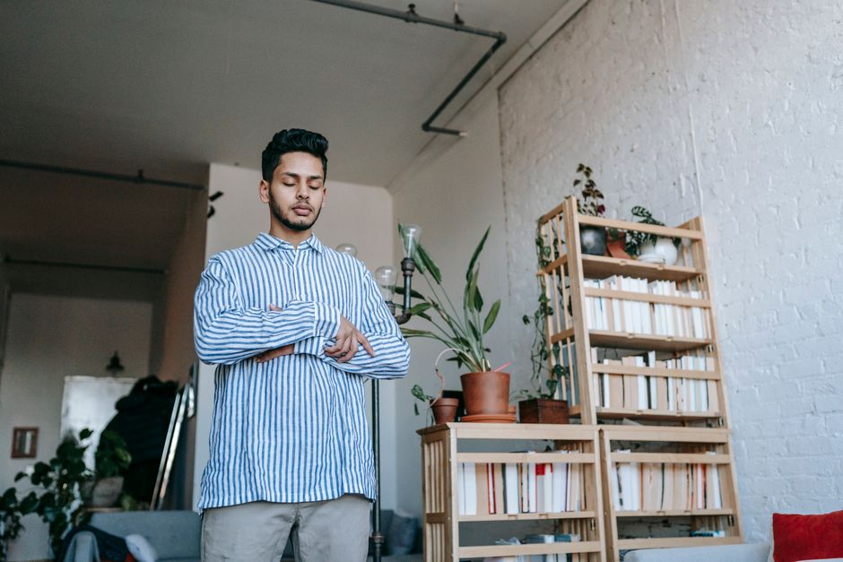 Man in a blue shirt standing in a bright living room