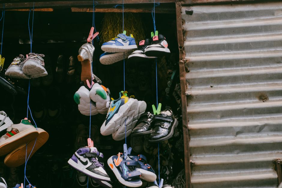 Colorful sneakers hanging for sale in an outdoor street market.
