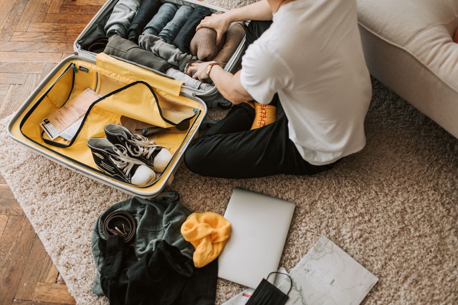 Open suitcase being packed with toiletries