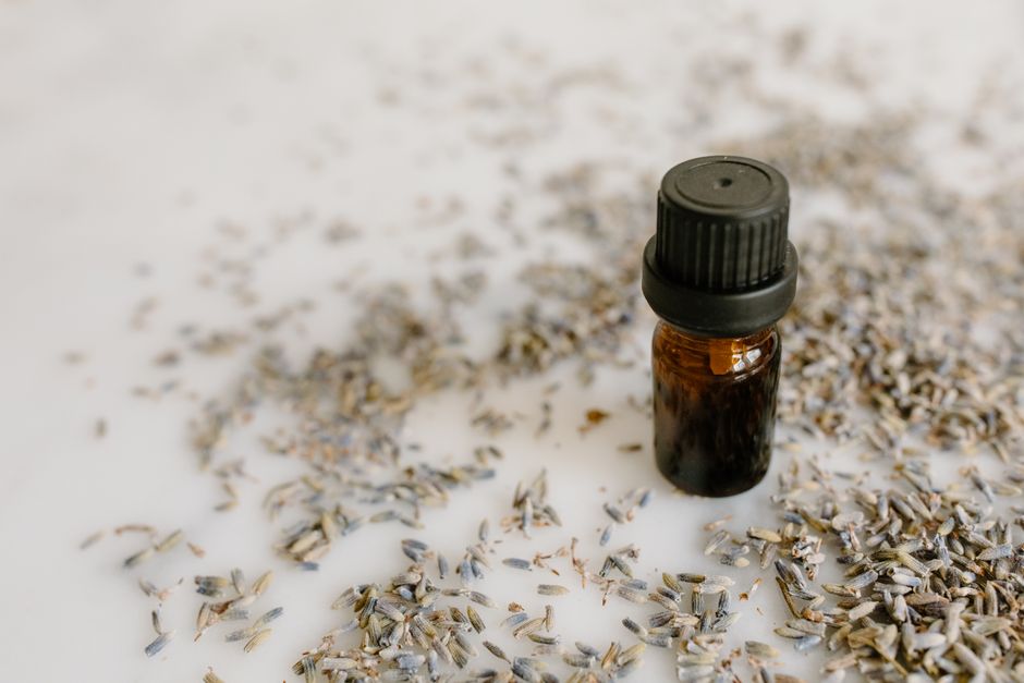 Small amber oil bottle lying among dried lavender