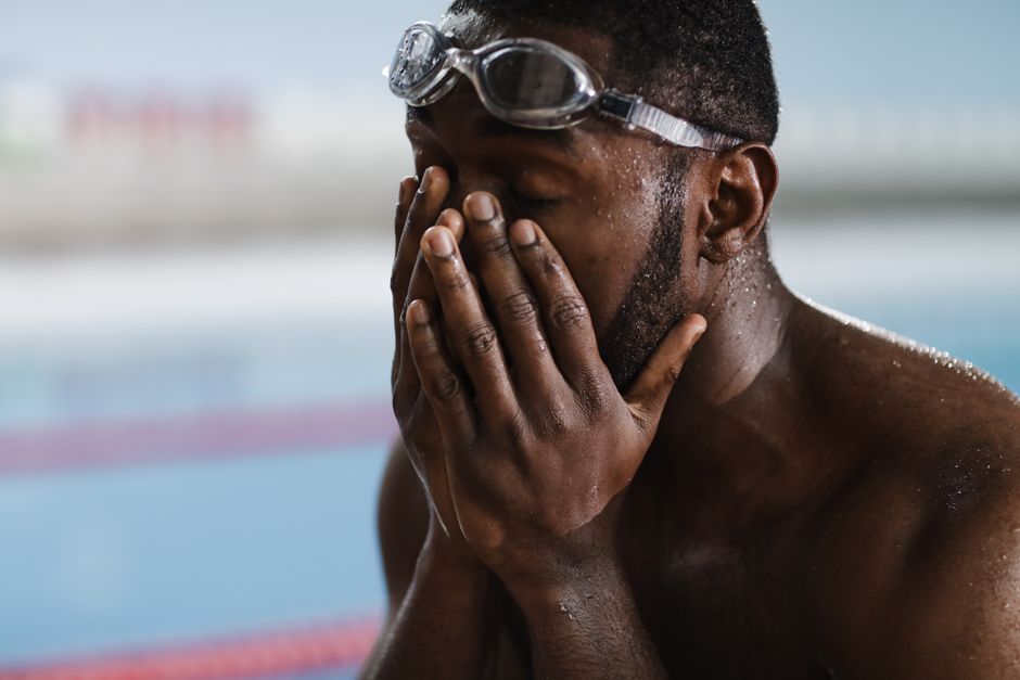 Swimmer with goggles on his head at the poolside